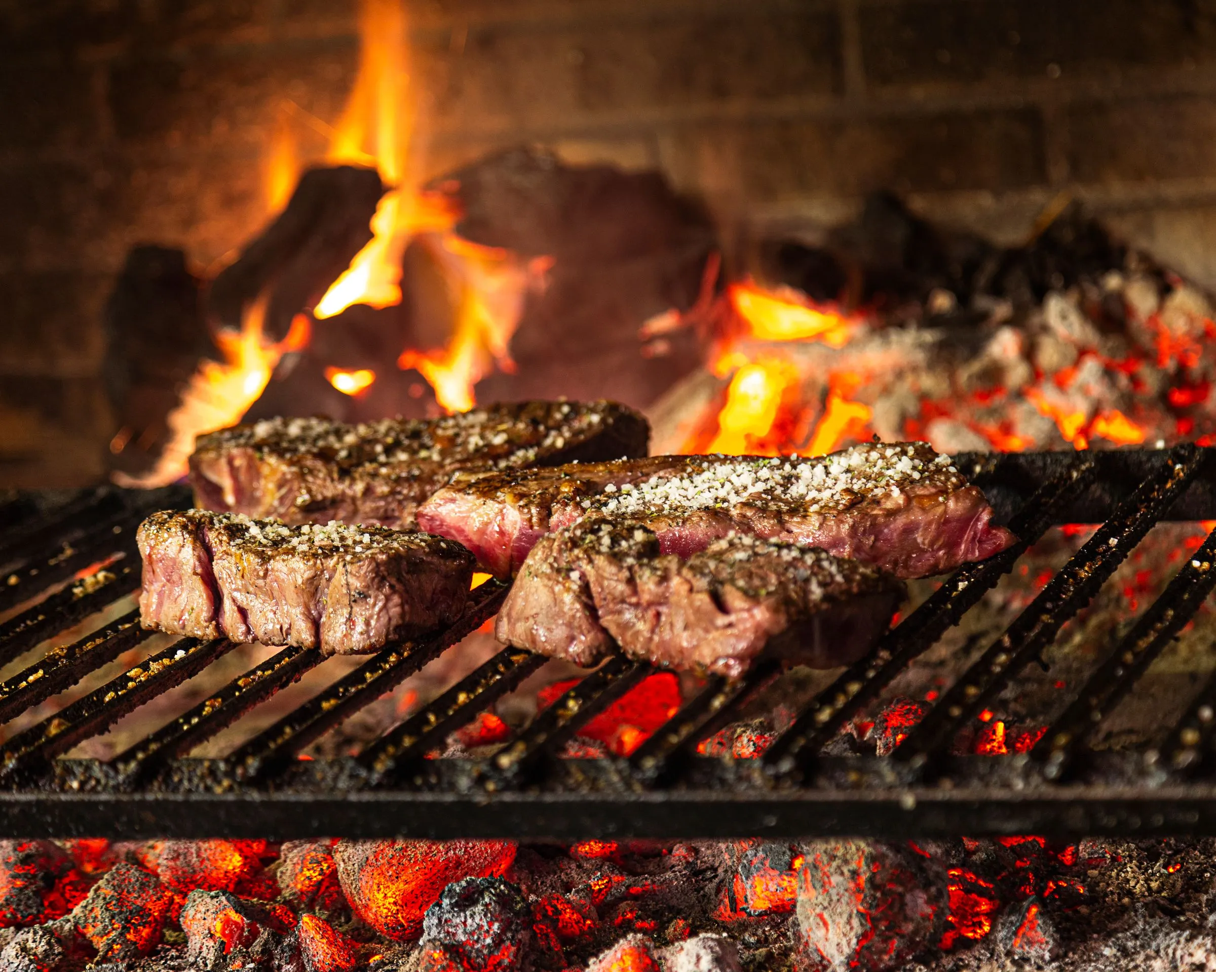 Txuletas de vaca vieja asándose sobre brasa de carbón de encina en Asador Artebe