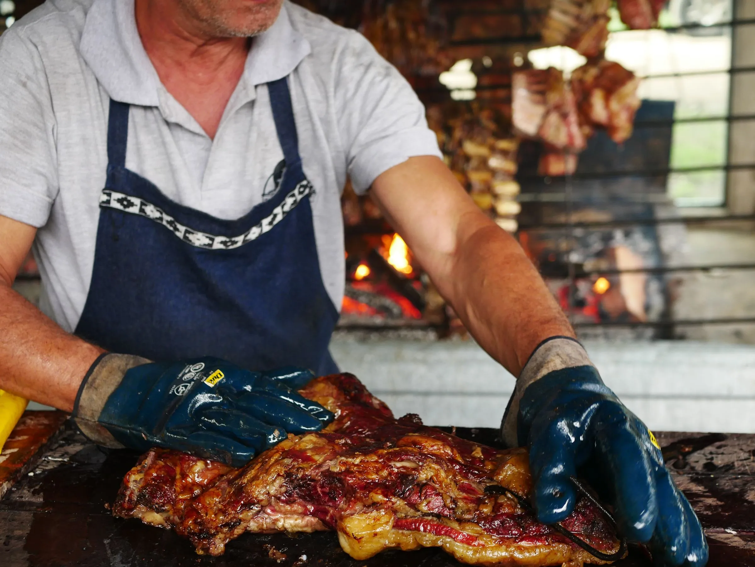Parrillero de Asador Artebe preparando carne recién asada sobre la brasa